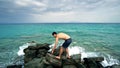 Lost alone male teen standing on sea rock