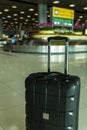 Lost black hardshell carry-on roller luggage left unattended at the baggage reclaim area at airport Royalty Free Stock Photo