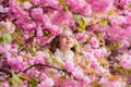 Lost in blossom. Botany concept. Girl tourist posing near sakura. Child on pink flowers of sakura tree background. Girl