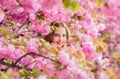 Lost in blossom. Tender bloom. Girl tourist posing near sakura. Child on pink flowers of sakura tree background. Botany
