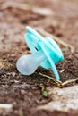 Lost blue baby nipple on the ground Royalty Free Stock Photo