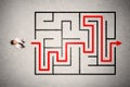 Lost businessman found the way in maze with red arrow