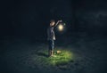 Lost child holding an old lamp in an apocalyptic environment Royalty Free Stock Photo