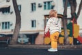 A lost child. A small baby is standing alone on the playground. The concept of adoption of children