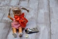 Lost childhood. Drugs and children. Doll with plastic bag, red satin bow, glue tube on light wooden background
