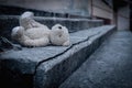 Lost childhood, loneliness and pain concept. Dirty teddy bear lying down outdoors