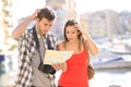 Lost confused tourists looking at map on vacation