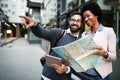 Lost happy couple in the city holding a map. Travel, tourism, people concept Royalty Free Stock Photo