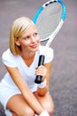 Lost in a daydream of victory. A young tennis player kneeling down and daydreaming of winning her match. Royalty Free Stock Photo