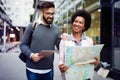 Lost happy couple in the city holding a map. Travel, tourism, people concept Royalty Free Stock Photo