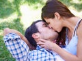 Lost in the haze of springtime romance. A young couple kissing in the park. Royalty Free Stock Photo