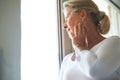 Lost in her thoughts. A thoughtful senior woman looking out of her window. Royalty Free Stock Photo