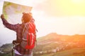 Lost hiker with backpack checks map to find directions Royalty Free Stock Photo