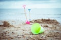 Lost, leaved children's beach toys - bucket, spade, and shovel on the sand on a cloudy day. No people. Devastation Royalty Free Stock Photo