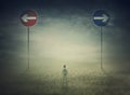 Lost man in the middle of nowhere with signposts showing two opposite directions to choose between left and right. Arrows aimed at Royalty Free Stock Photo