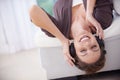 Lost in the music. A young woman lying upside down listening to music over her headphones. Royalty Free Stock Photo