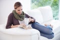 Lost in a page-turner...A young woman relaxing on her couch with a book and a cup of coffee. Royalty Free Stock Photo