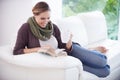 Lost in a page-turner...A young woman relaxing on her couch with a book and a cup of coffee. Royalty Free Stock Photo