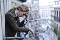 Lost and sad woman at home balcony suffering depression looking thoughtful and solitary