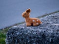 Lost stuffed animal that looks like a bamby toy sitting on a stone