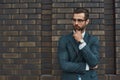 Lost in thoughts. Portrait of handsome bearded businessman in eyeglasses and formal wear thinking about something while