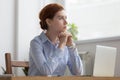 Lost in thoughts woman sits at workplace desk in office