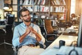 Lost in thoughts. Young bearded businessman in eyeglasses and formal wear working on computer and thinking about