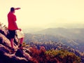 Lost tourist on peak looking into landscape while check paper map, hiking in nature. Royalty Free Stock Photo