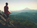 Lost tourist on peak looking into landscape while check paper map, hiking in nature. Royalty Free Stock Photo