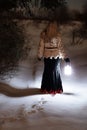 Lost young woman in the winter forest with a lantern Royalty Free Stock Photo