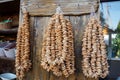 A lot of bagels on ropes hang on wooden wall in grocery