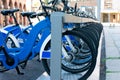 A lot of bicyles for hire ion the parking station in the street.Renting public bikes system.