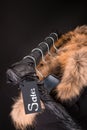 lot of black coats, jacket with fur on hood hanging clothes rack. background. Sale inscription. friday.Close up.