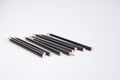 A lot of black pencils are on the white table. Royalty Free Stock Photo