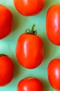 A lot of bright red juicy tomatoes on a green background. Royalty Free Stock Photo