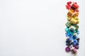 A lot of buttons and reels with colorful threads, laid out on a white background in the colors of the rainbow. Copy space