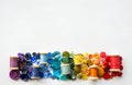 A lot of buttons and reels with colorful threads, laid out on a white background in the colors of the rainbow. Copy space Royalty Free Stock Photo