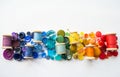 A lot of buttons and reels with colorful threads, laid out on a white background in the colors of the rainbow. Copy space Royalty Free Stock Photo