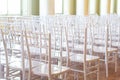 A lot of chairs indoors near the window. Rows white chairs in the hall. Empty room with many modern seats, nobody in big lobby. Royalty Free Stock Photo