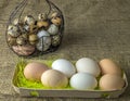 A lot of chicken eggs and quail eggs lies of a metal structure in the shape of a heart and an ear lying on the wooden table Royalty Free Stock Photo