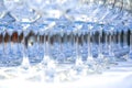 A lot of clean crystal glasses on white tablecloth prepared for big party. Blurred. Catering and restaurant utensils Royalty Free Stock Photo