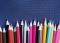 A lot of colored close-up pencils on a dark blue fabric background. Top view, copy space. Royalty Free Stock Photo