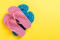 A lot of colored flip flops on yellowbackground. Top view with copy space