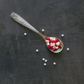 A lot of colored pills and medicines, vitamins, capsules in a spoon on a dark background. Royalty Free Stock Photo