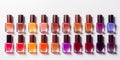 A lot of colorful bottles with nail polish lie on white background top view close up.Row of nail polishes for manicure Royalty Free Stock Photo