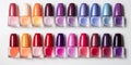 A lot of colorful bottles with nail polish lie on white background top view close up.Row of nail polishes for manicure Royalty Free Stock Photo