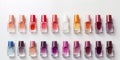 A lot of colorful bottles with nail polish lie on white background top view close up.Row of nail polishes for manicure Royalty Free Stock Photo