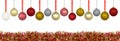 A lot of colorful Christmas baubles hanging on a ribbon over a colorful tinsel, isolated on a white background with a clipping pat Royalty Free Stock Photo