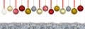 A lot of colorful Christmas baubles hanging on a ribbon over a silver tinsel, isolated on a white background with a clipping path Royalty Free Stock Photo