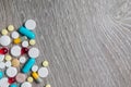 Lot of colorful medication and pills from above on grey wooden background. Copy space. Top view, frame. Painkillers, tablets, gene